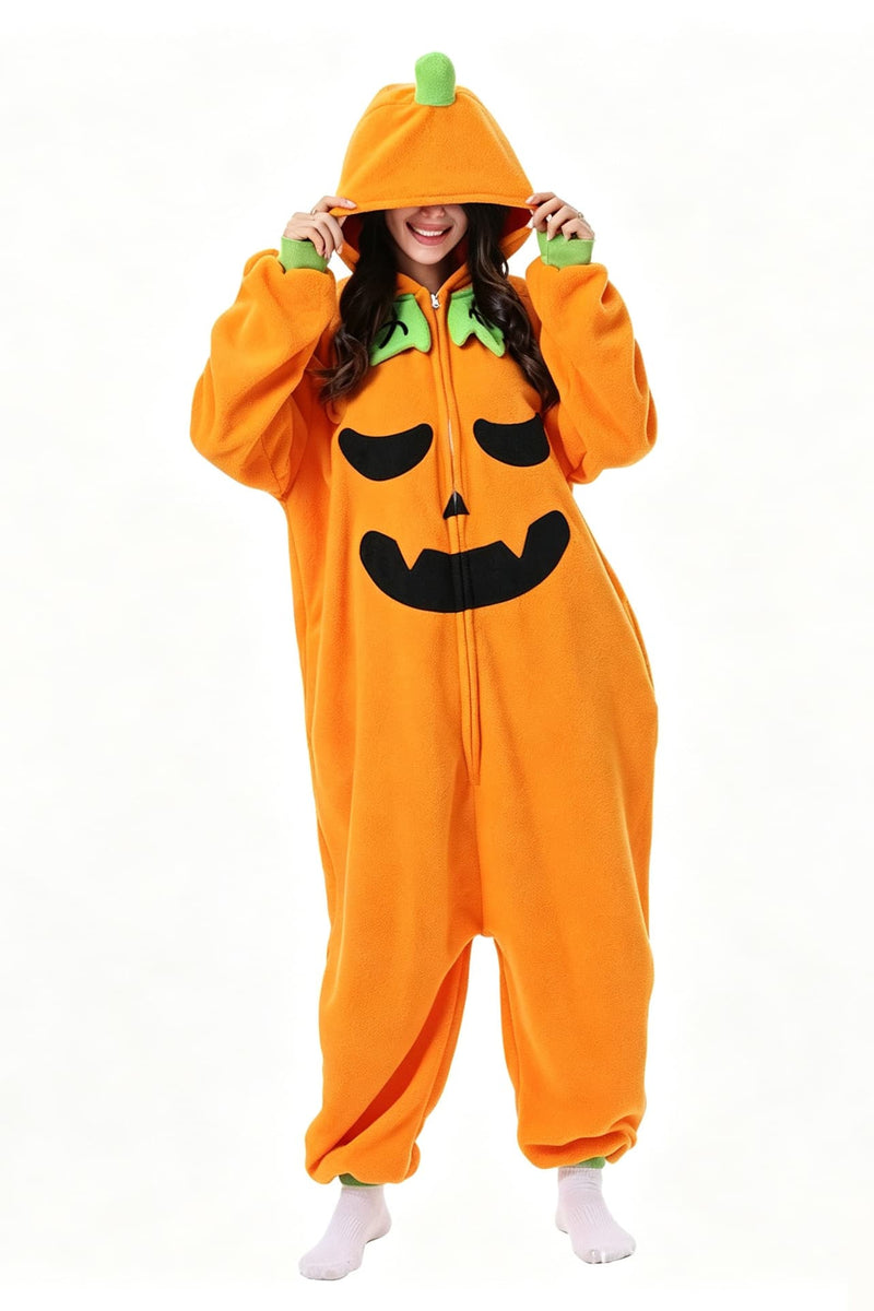 A woman wearing a bright orange pumpkin-shaped kigurumi onesie with a green leaf detail on the hood and a black jack-o'-lantern face, posing against a solid white background.