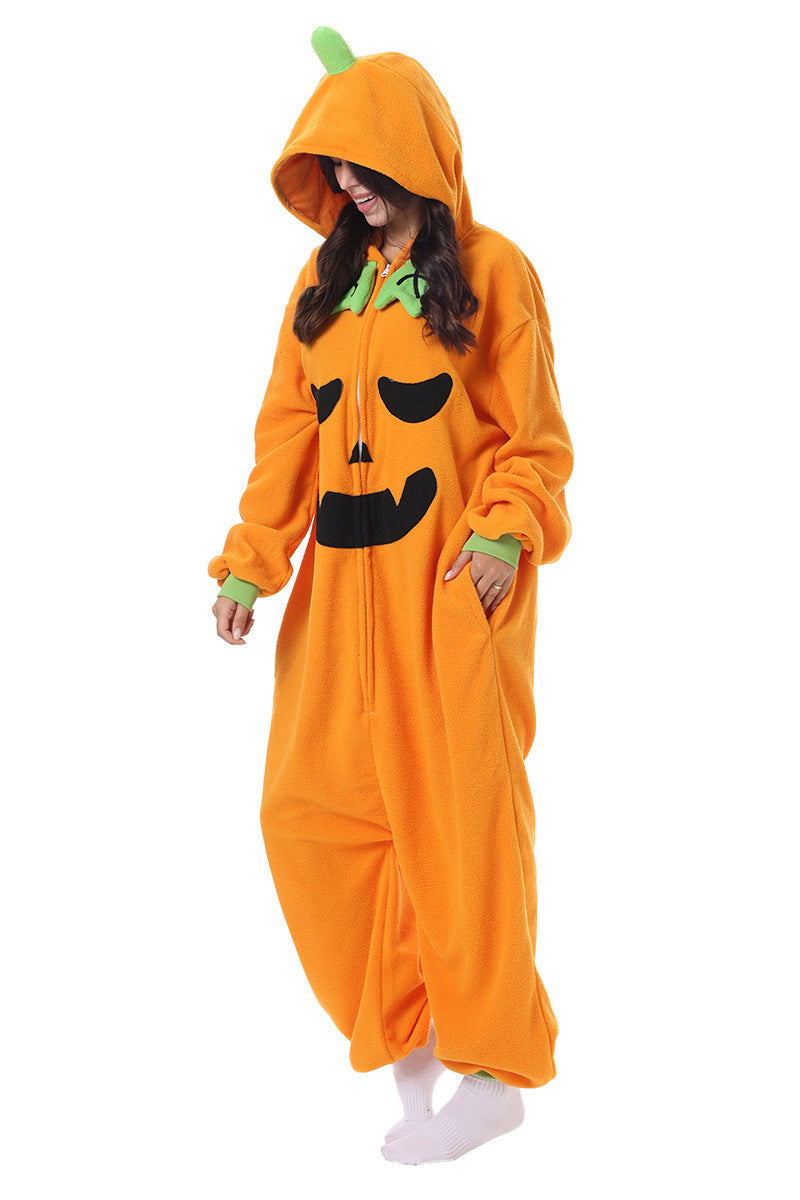 A woman wearing a full-body orange pumpkin kigurumi onesie with a black jack-o'-lantern face and green stem detail, standing against a plain white background.