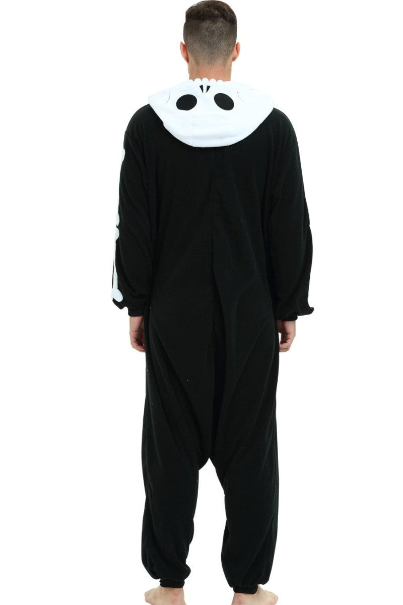 A man viewed from the back wearing a black one-piece kigurumi pajama with a white hood featuring a skull design.